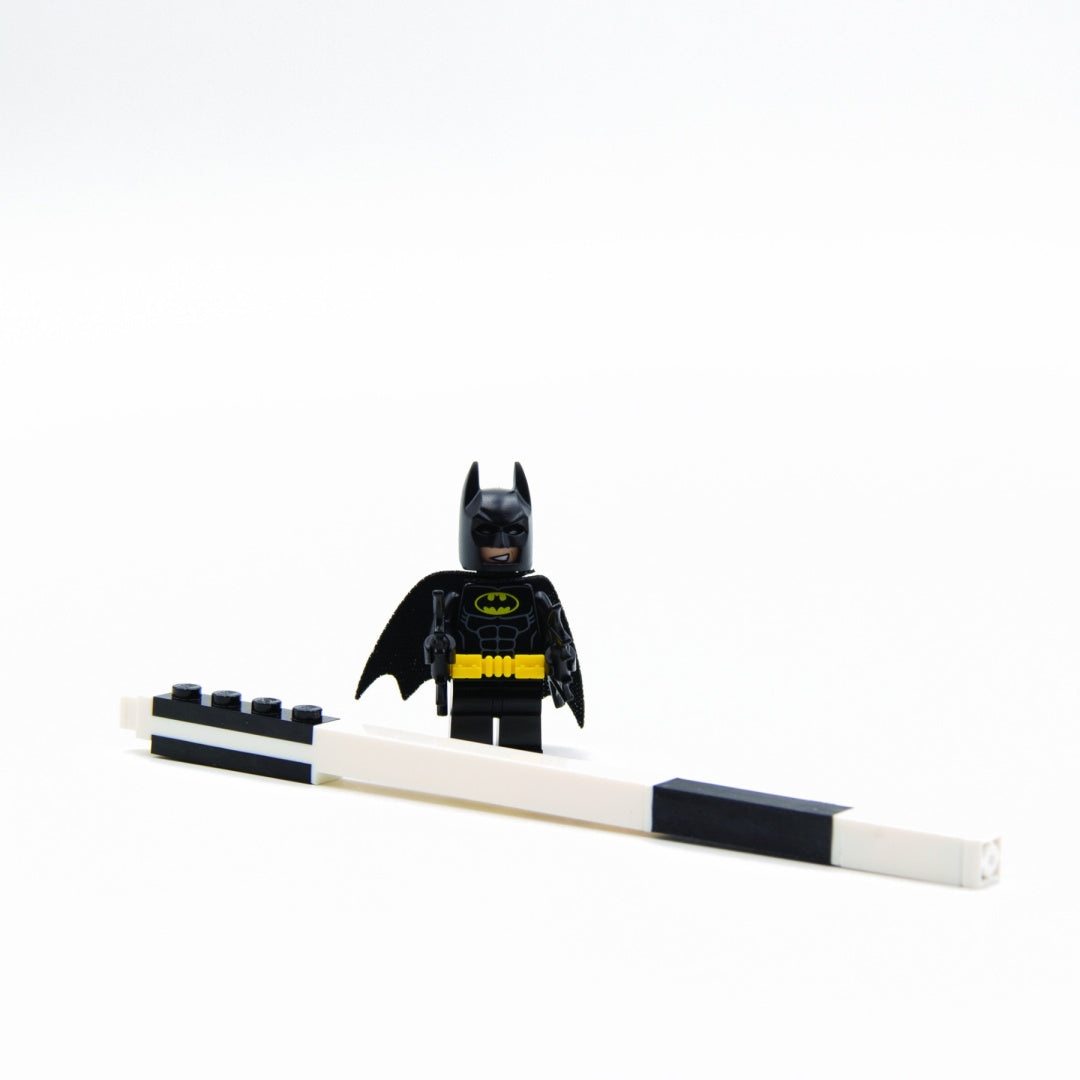 długopis żelowy LEGO Batman z czarną figurką Batmana stojącą obok biało-czarnego długopisu