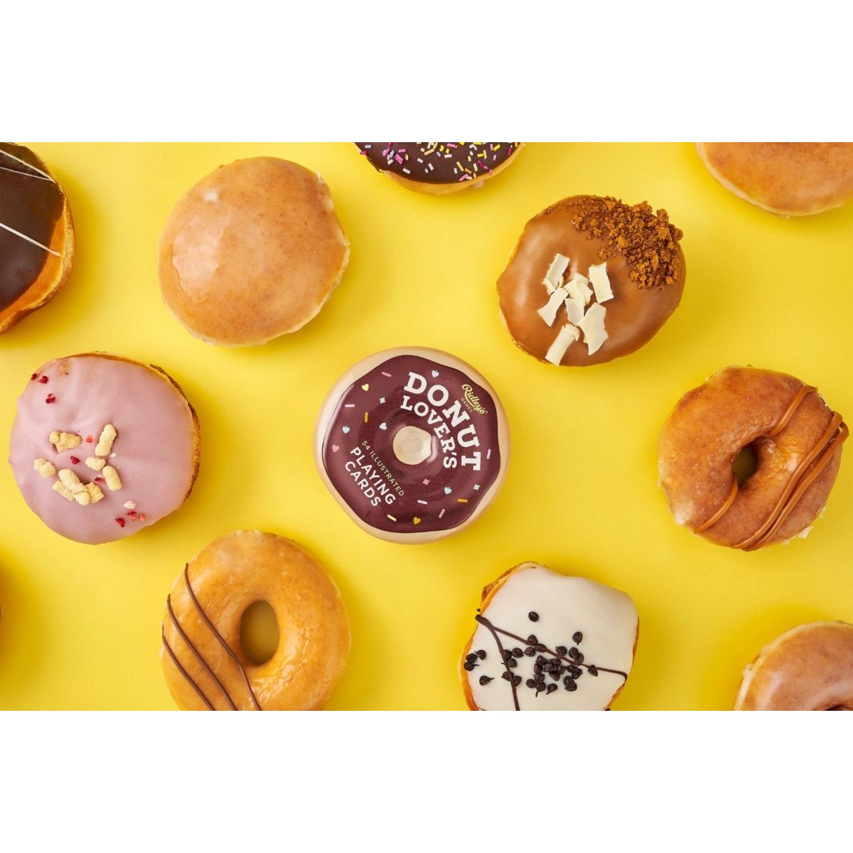 Karty do gry z motywem donutów w opakowaniu otoczonym przez pyszne kolorowe pączki z różnymi polewami