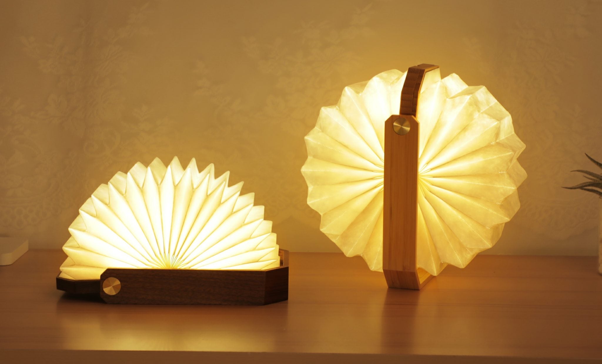Inteligentna lampa origami orzech od WABOBA AB z podświetleniem i drewnianą podstawą ustawiona na stole