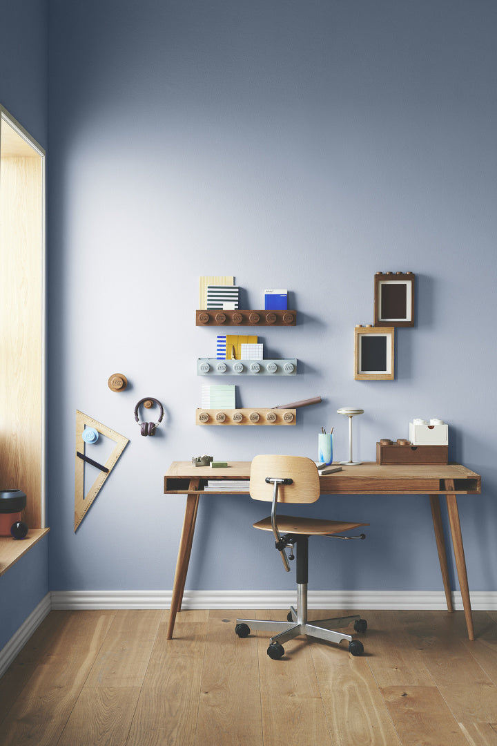 Nowoczesne biurko z drewnianym krzesłem i na ścianie zamontowana drewniana półka LEGO do przechowywania książek i dekoracji
