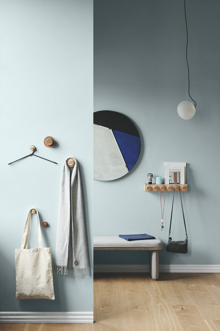 Nowoczesne drewniane wieszaki LEGO od BV JACOB COMPANY na makatkę, szal i torebkę przy jasnoszarej ścianie