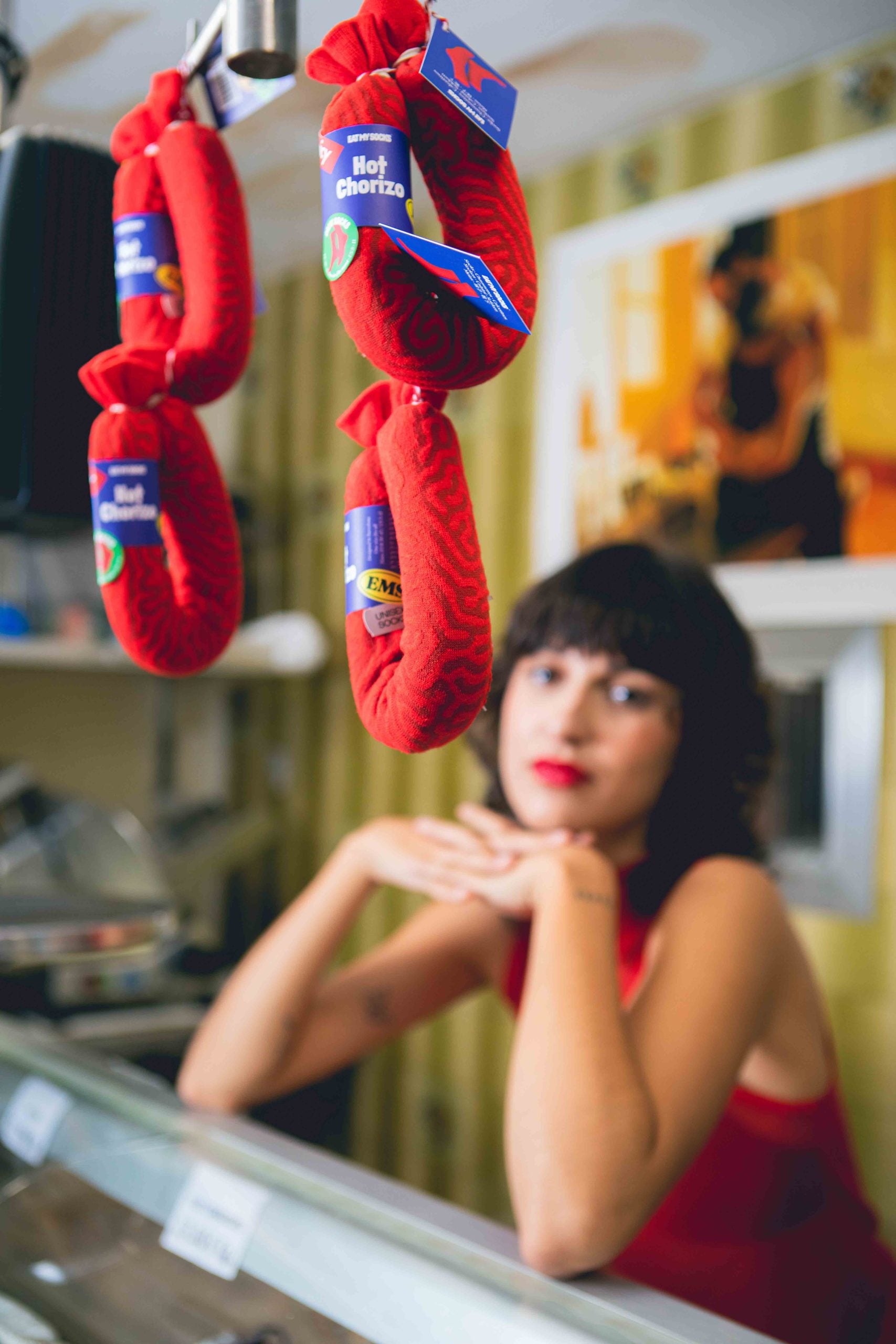 Czerwone skarpetki w kształcie kiełbasy chorizo wiszące na wystawie w sklepie EMS