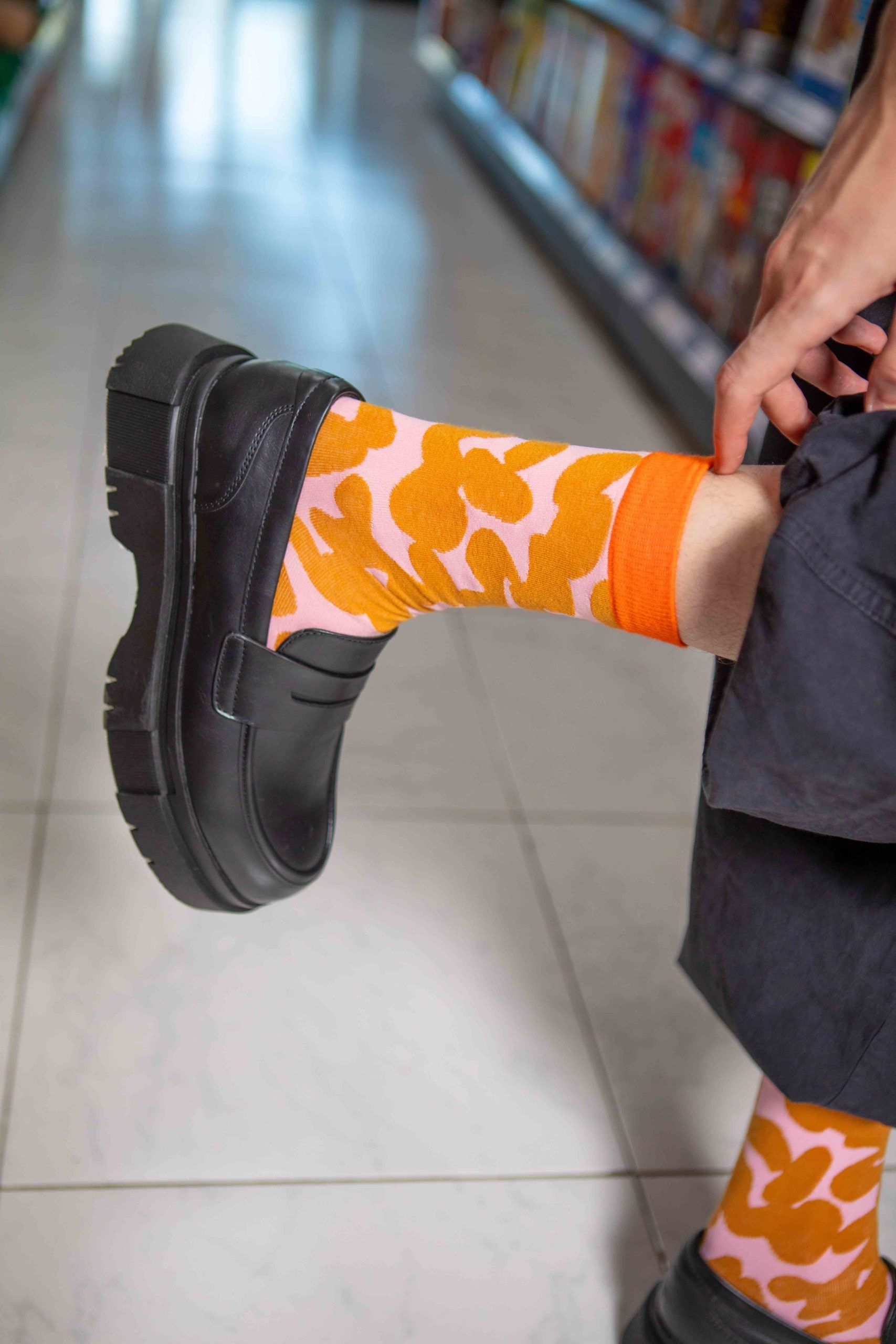 Pomarańczowe skarpetki peanut butter z wzorem w liście noszone z czarnymi butami EMS