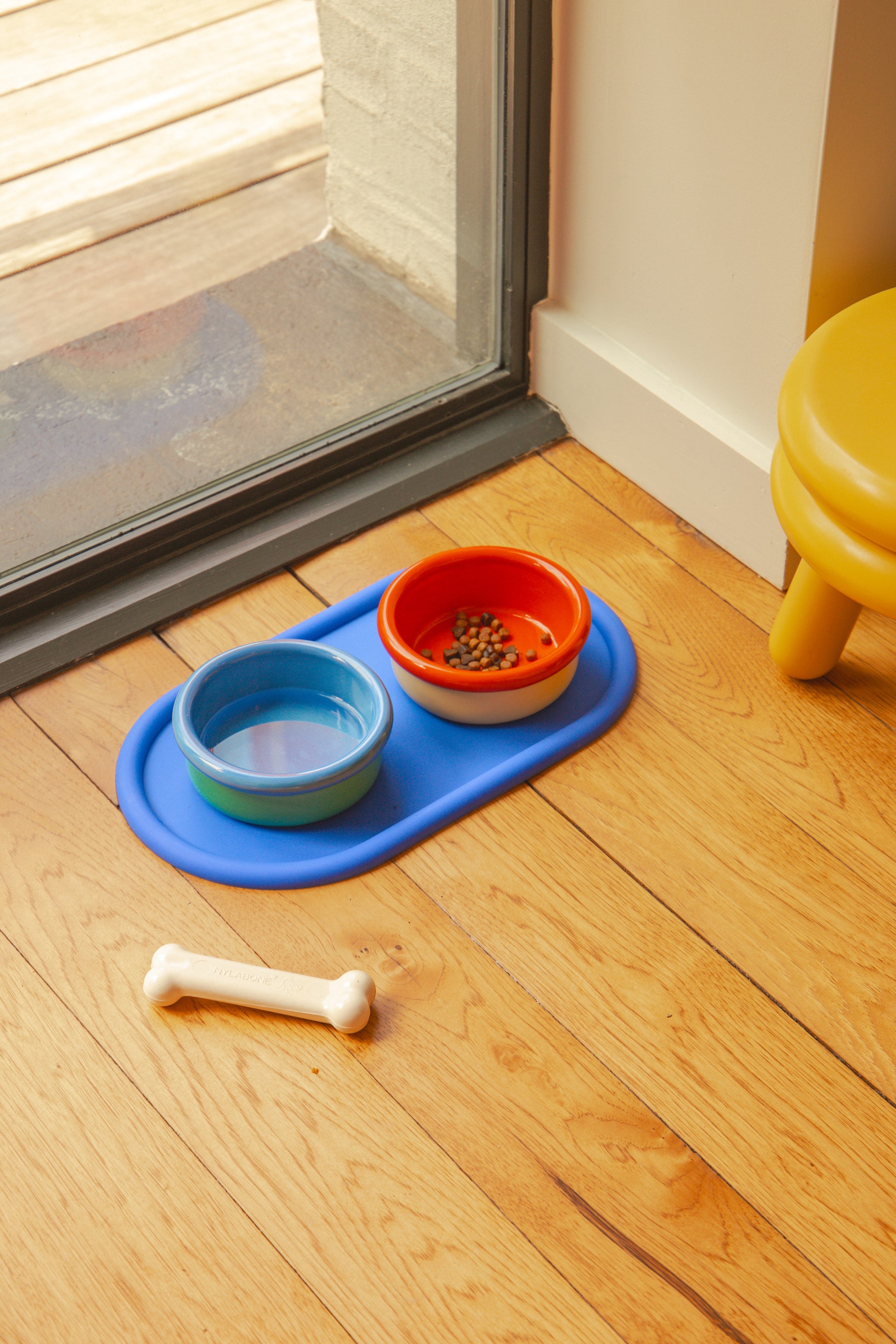 Zestaw miseczek dla zwierząt Areaware z niebieską podkładką i kolorowymi miskami na wodę i karmę