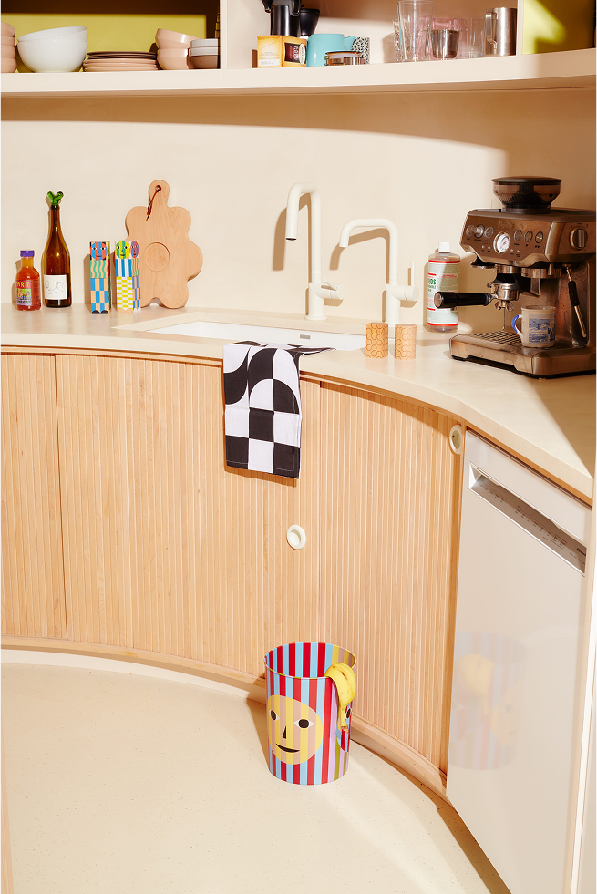 Kolorowy kosz na śmieci design Areaware w nowoczesnej kuchni z drewnianymi szafkami