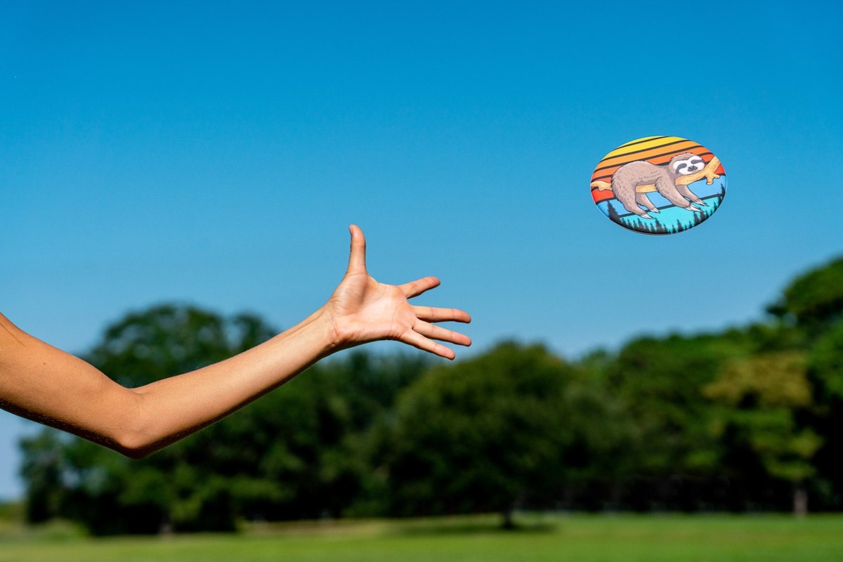 Rzucanie frisbee Waboba Wingman Retro Palm na tle nieba i zielonego parku