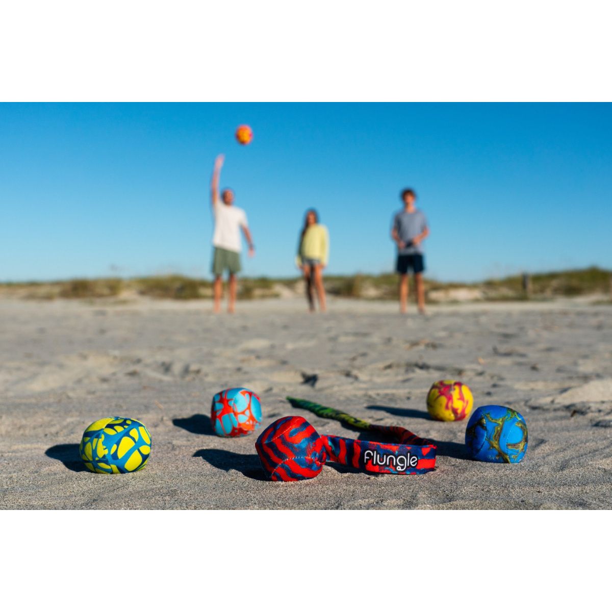 Gra zręcznościowa Waboba Flungle z kolorowymi piłkami na plaży podczas zabawy z przyjaciółmi