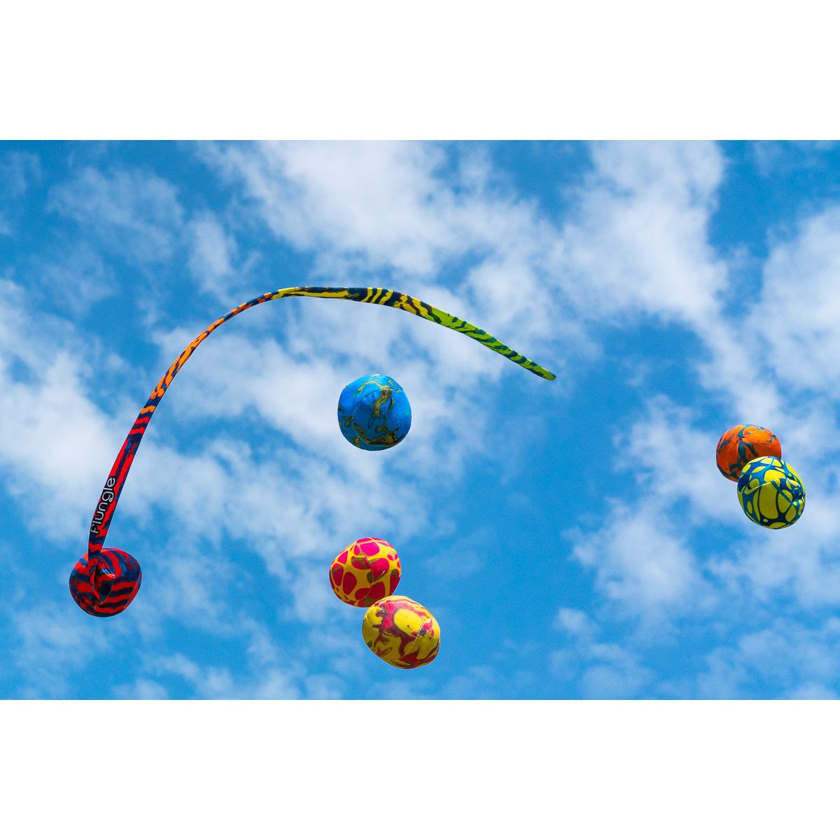 Kolorowa gra zręcznościowa Waboba Flungee z piłkami i elastycznym paskiem na tle nieba