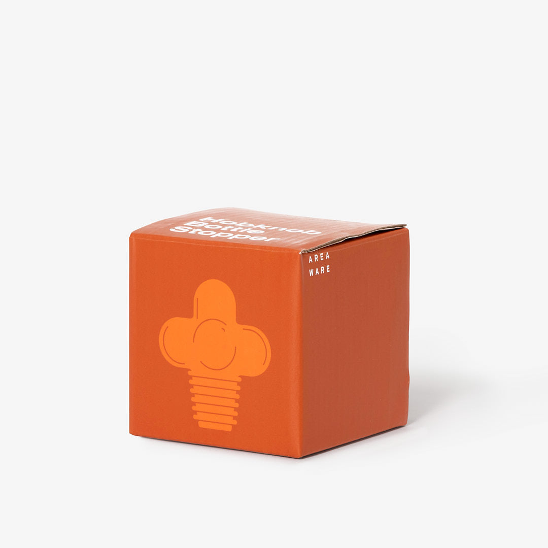 Pomarańczowe opakowanie korek do butelek designerski marki Areaware na białym tle