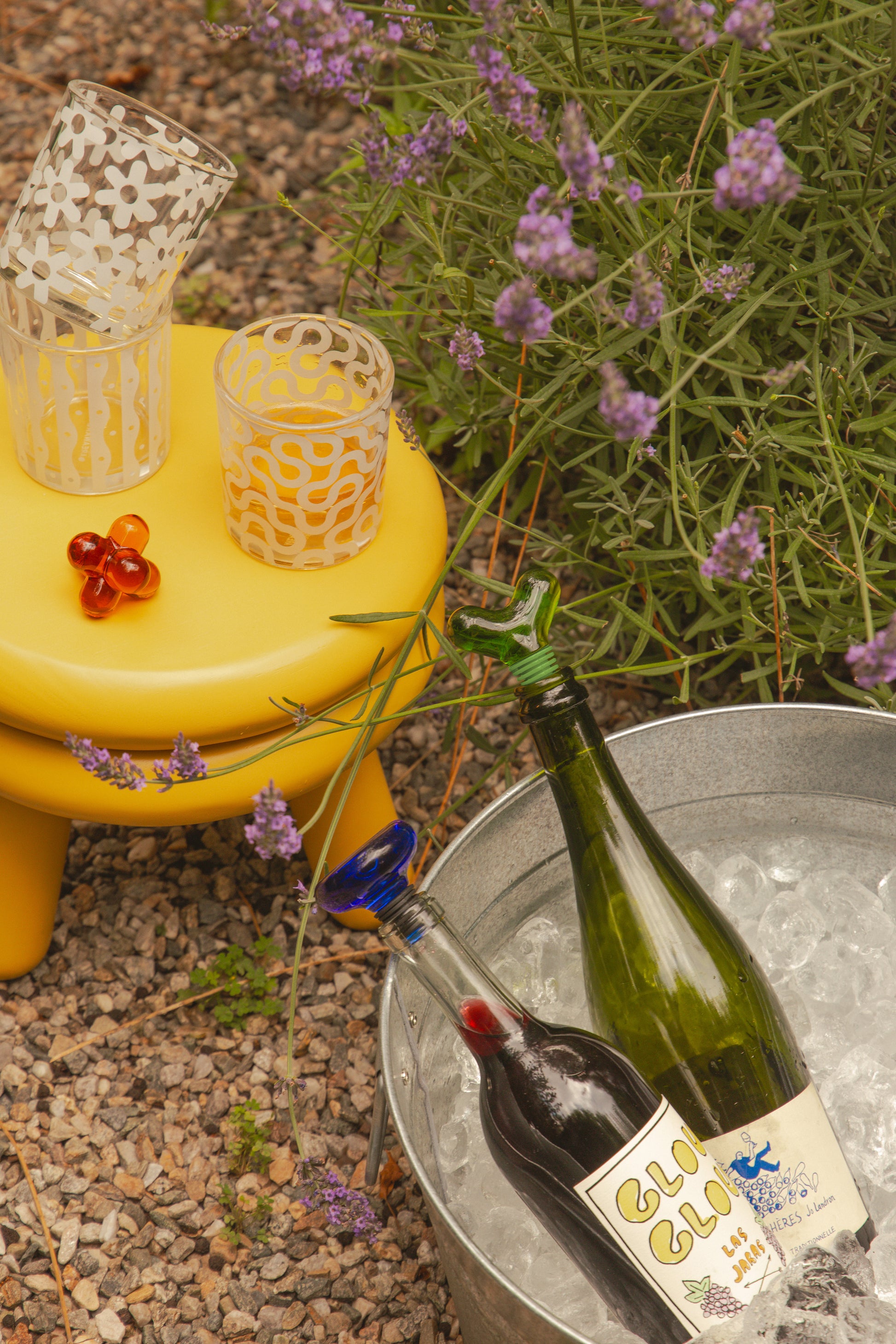 Designerski korek do butelek Areaware na zielonej butelce w metalowej chłodziarce z lodem