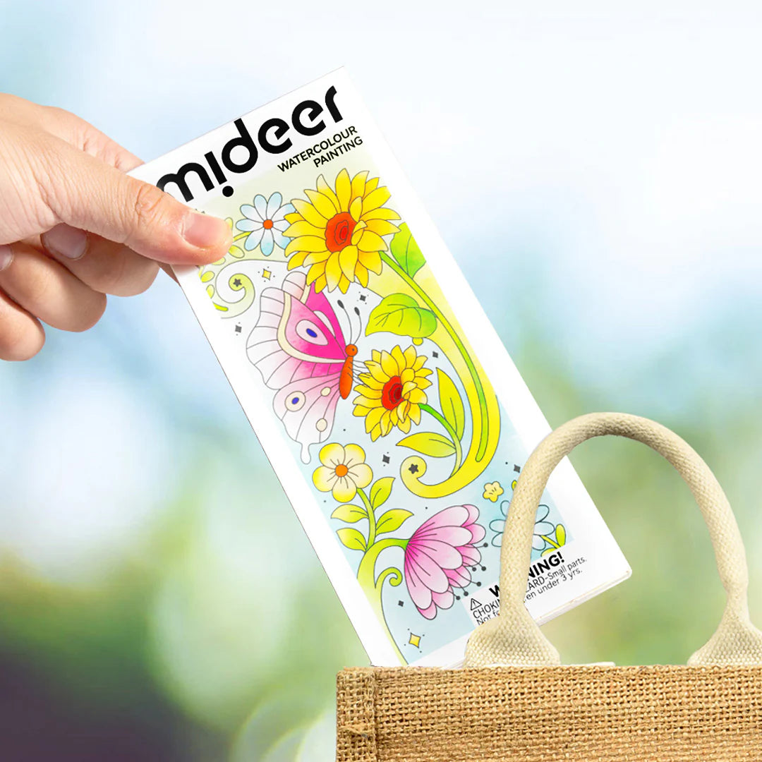 Kolorowanka akwarelowa kwiaty z motylem trzymana nad torbą z juty marki Yamann