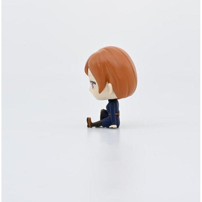 Figurka bobble head Jujutsu Kaisen z czerwonymi włosami w granatowym stroju siedząca na białym tle