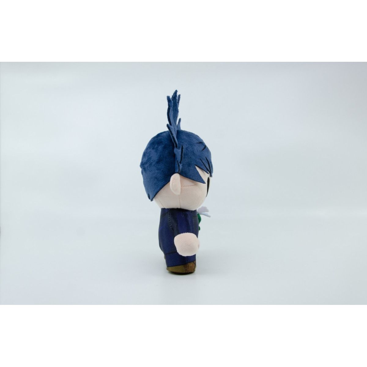 Pluszowa figurka Jujutsu Kaisen w granatowym stroju widziana z boku na białym tle