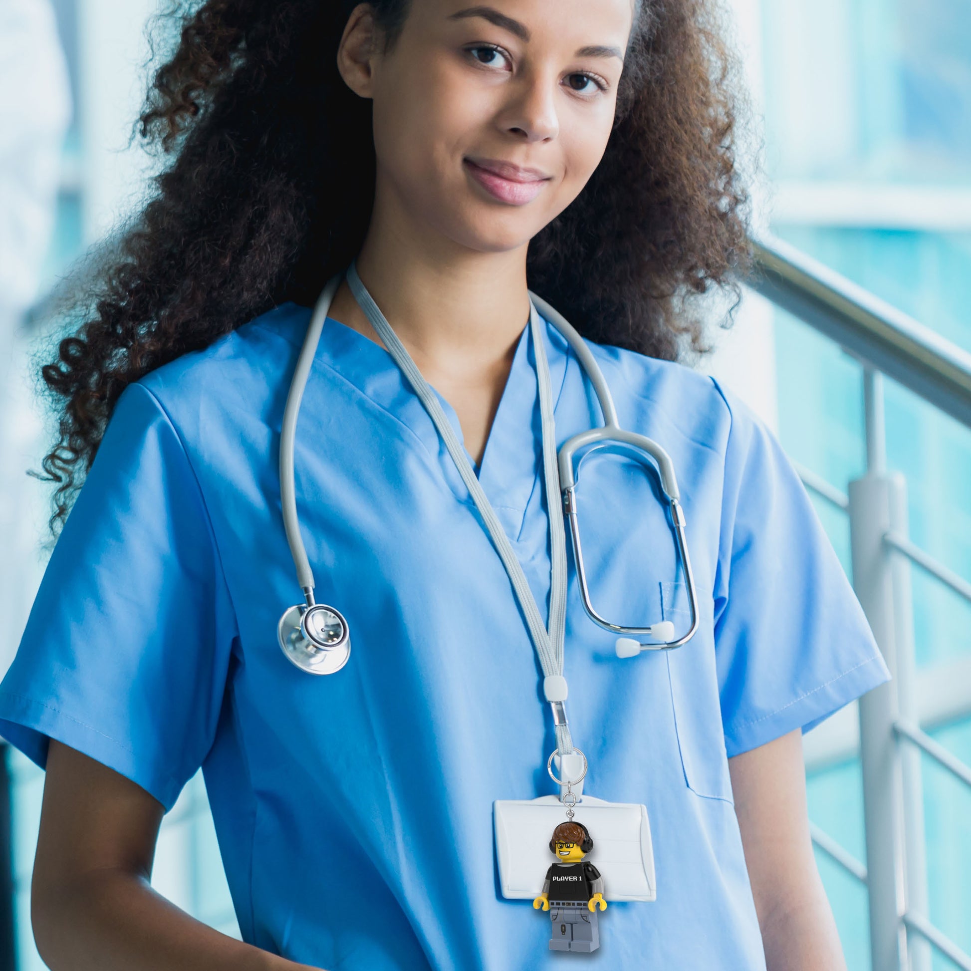 Brelok z latarką LEGO Gamer zawieszony na identyfikatorze pielęgniarki w niebieskim uniformie