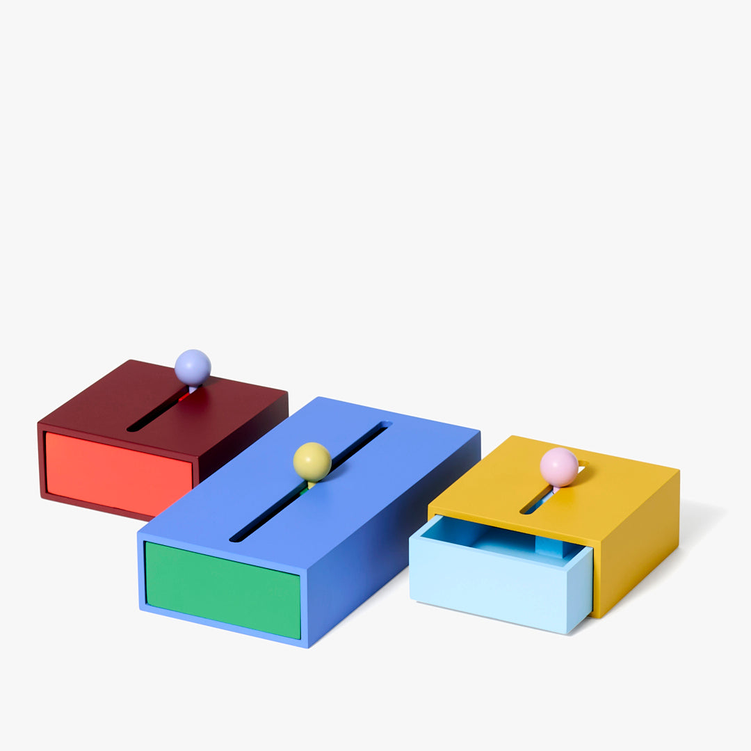 Kolorowe pojemniki Cache Box Areaware w trzech rozmiarach z szufladami i kulkami na górze