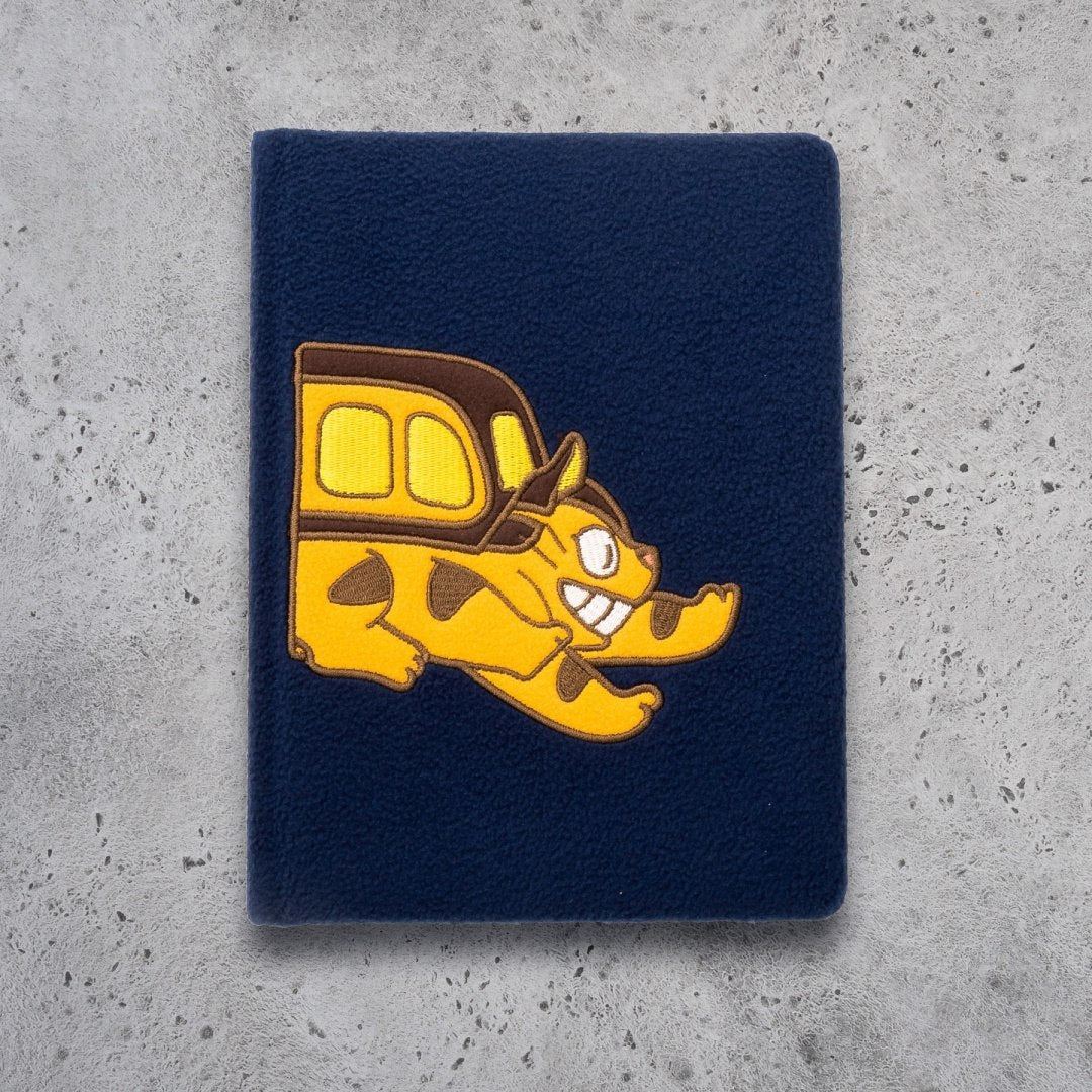 Granatowy pluszowy notatnik kotobus z żółtą aplikacją kota w stylu kreskówkowym