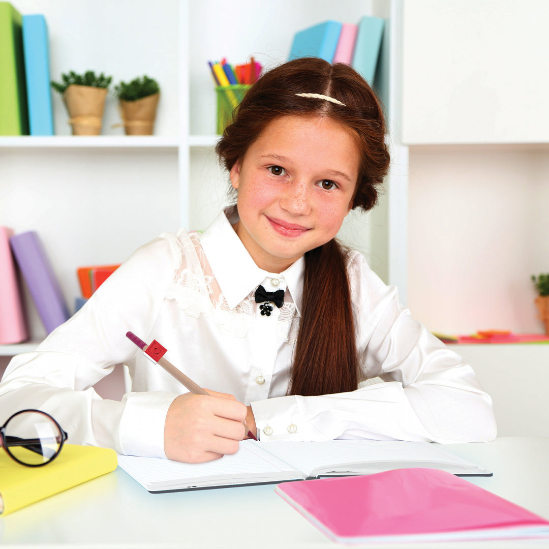 Dziewczynka rysująca przy biurku z kredkami LEGO 12 sztuk w jasnym pokoju do nauki