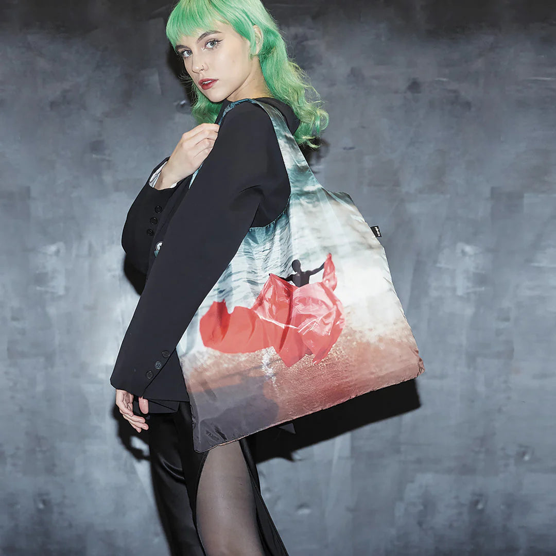 Torba LOQI Cristina de Middel z kolorowym nadrukiem noszona przez kobietę na ramieniu