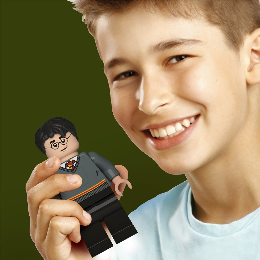Chłopiec trzymający latarkę LEGO Harry Potter w kształcie figurki Harry'ego Pottera