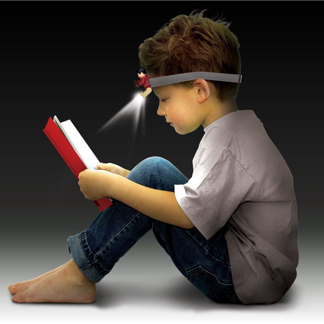 Dziecko czytające książkę z założoną na głowę latarką czołową Harry Potter LEGO od MOB
