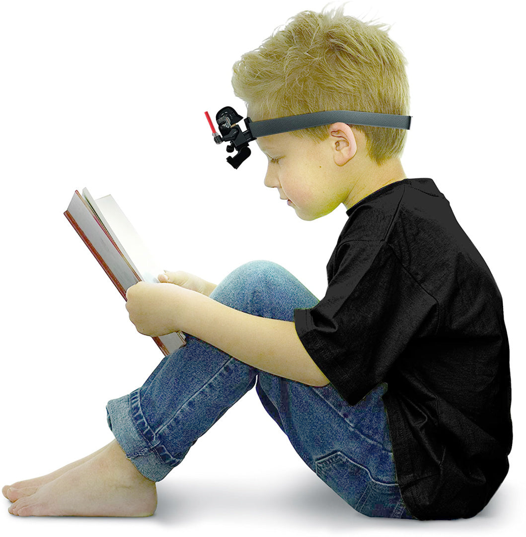 Chłopiec czytający książkę z założoną na głowę latarką czołową LEGO Star Wars