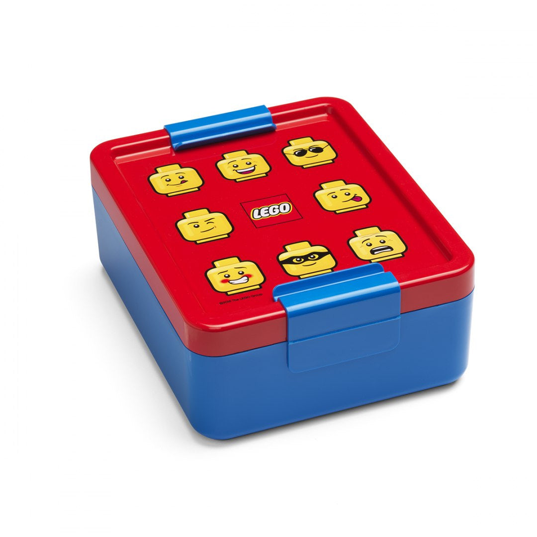 Kolorowy lunchbox LEGO dla dzieci z ilustracjami twarzy figurek LEGO i niebieskim zamknięciem