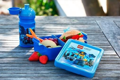Lunchbox LEGO City dla dzieci z niebieskim bidonem i przekąskami na drewnianym stole