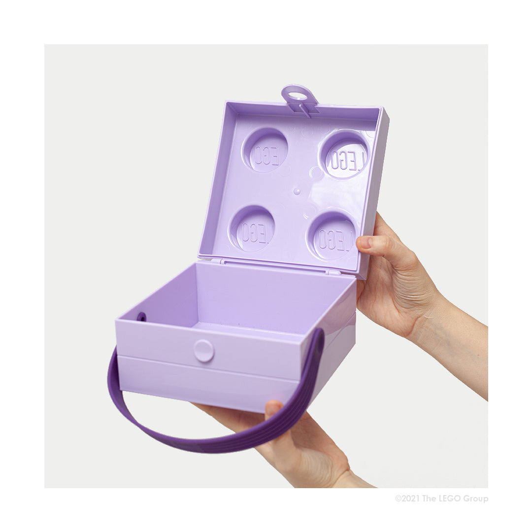 Lunchbox LEGO fioletowy z uchwytem, otwarty, trzymany w dłoniach, pojemnik na przekąski dla dzieci