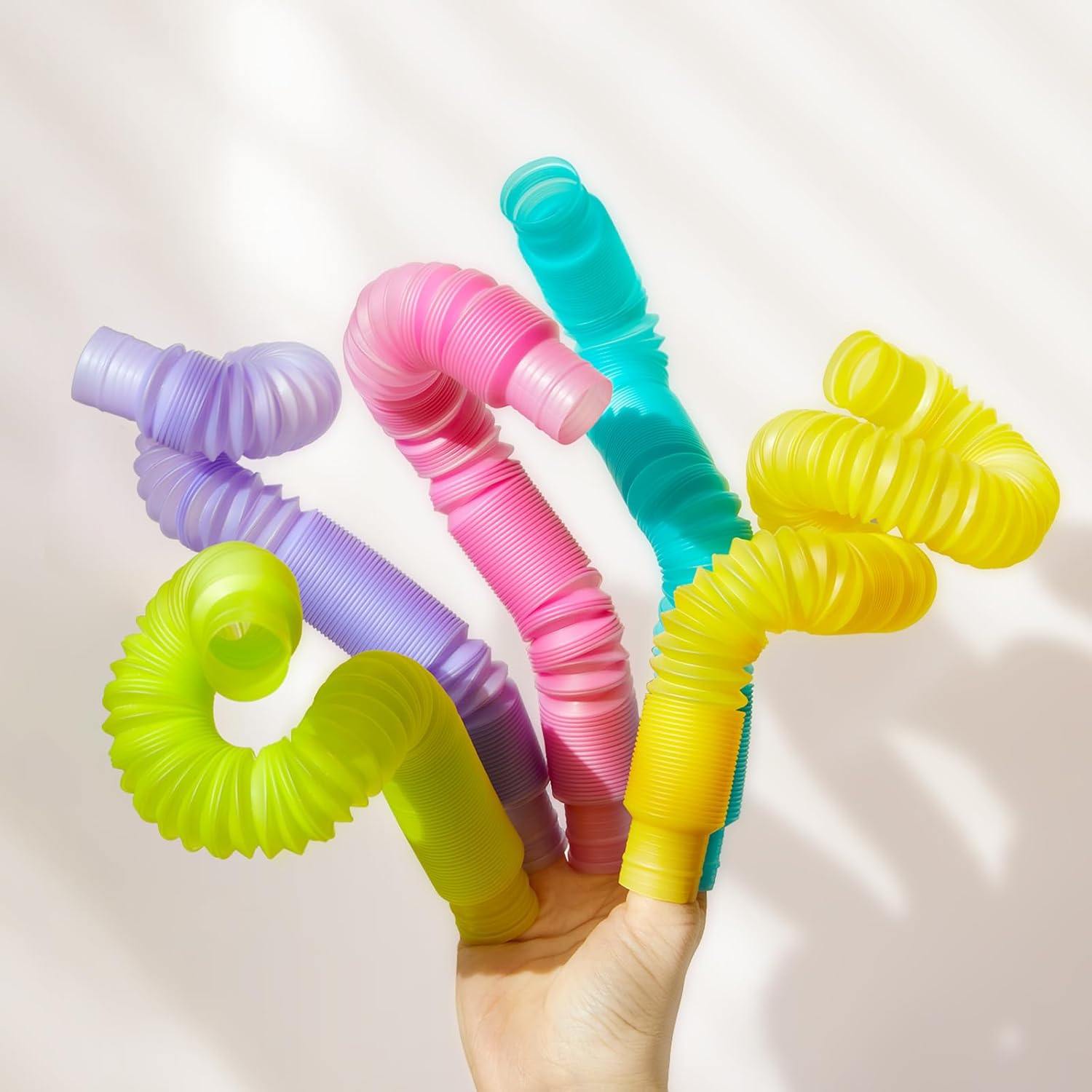 Zestaw świecących rurek dla dzieci w różnych kolorach trzymany w dłoni