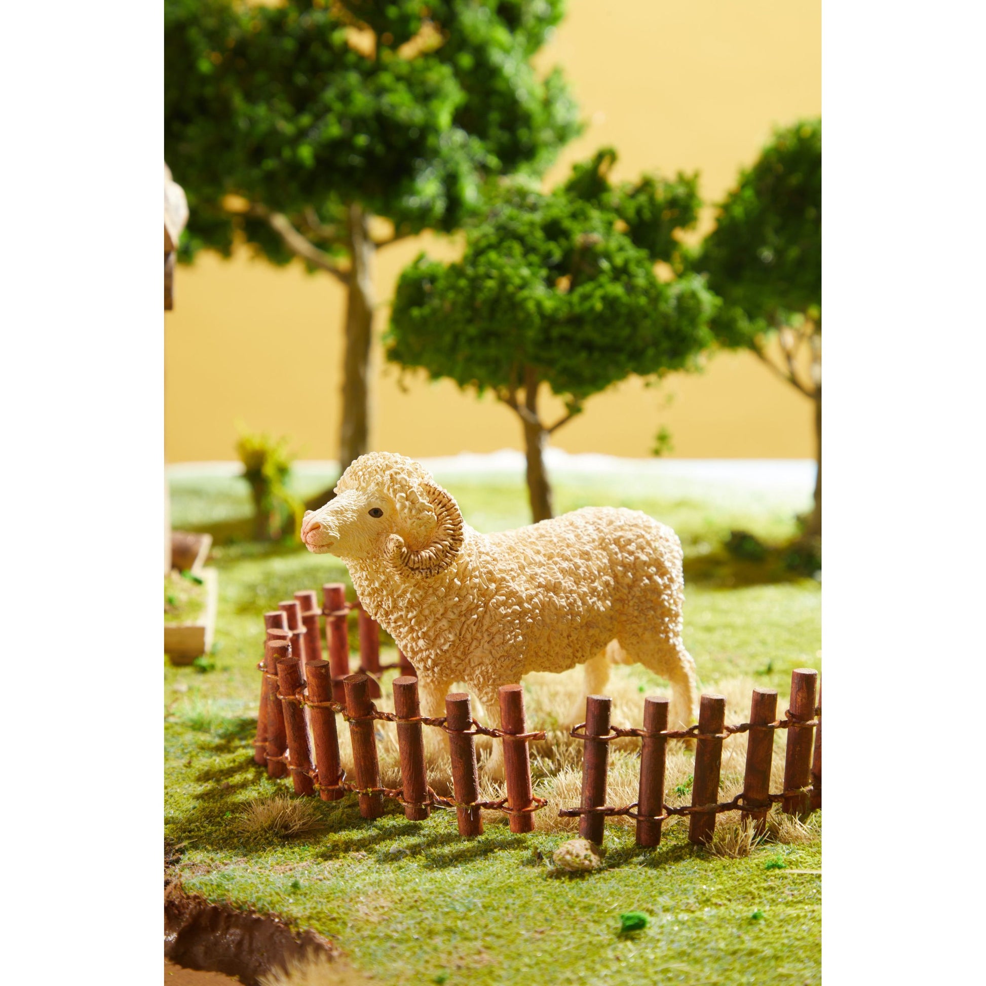 Zestaw figurek zwierząt na farmie z modelową owcą w plastikowym ogrodzeniu i drzewami