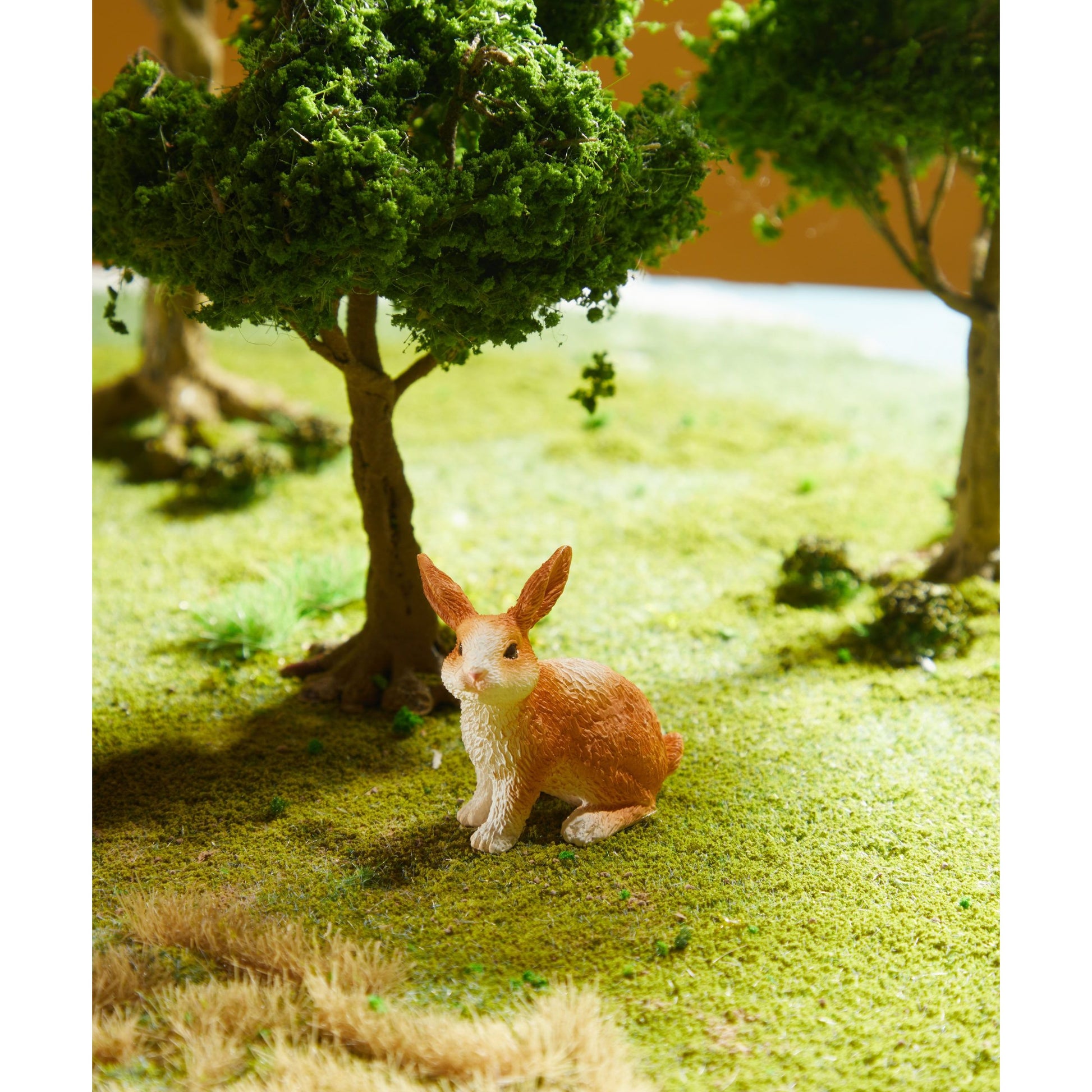 Zestaw figurek zwierząt na farmie z modelem królika na trawie pod drzewem