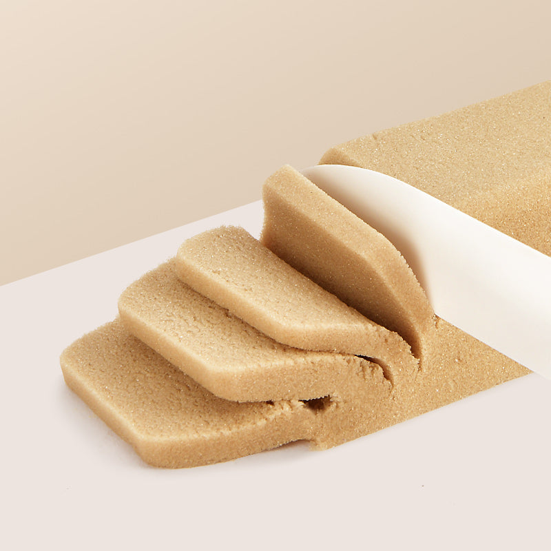 Piasek magiczny dla dzieci w kolorze piaskowym krojony białym nożem na plasterki