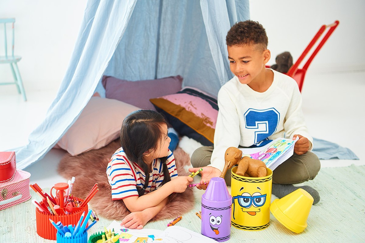 Dzieci bawiące się zabawkami z małym pojemnikiem Crayola czerwonym i innymi pojemnikami na zabawki