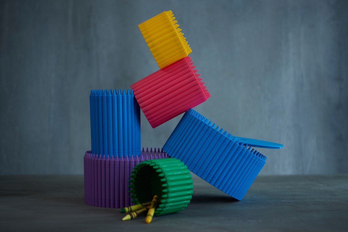 Kolorowe małe przybory Crayola w różnych kształtach na stole, mały przybornik Crayola czerwony na środku