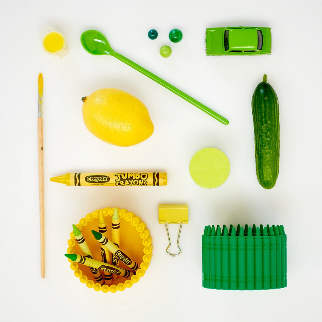 Zielono-żółty przybornik na kredki Crayola z kredkami i dodatkami na białym tle