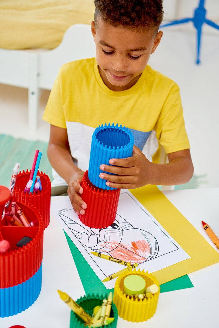 Dziecko bawi się kolorowymi pojemnikami organizującymi przybory na biurku mały przybornik Crayola różowy