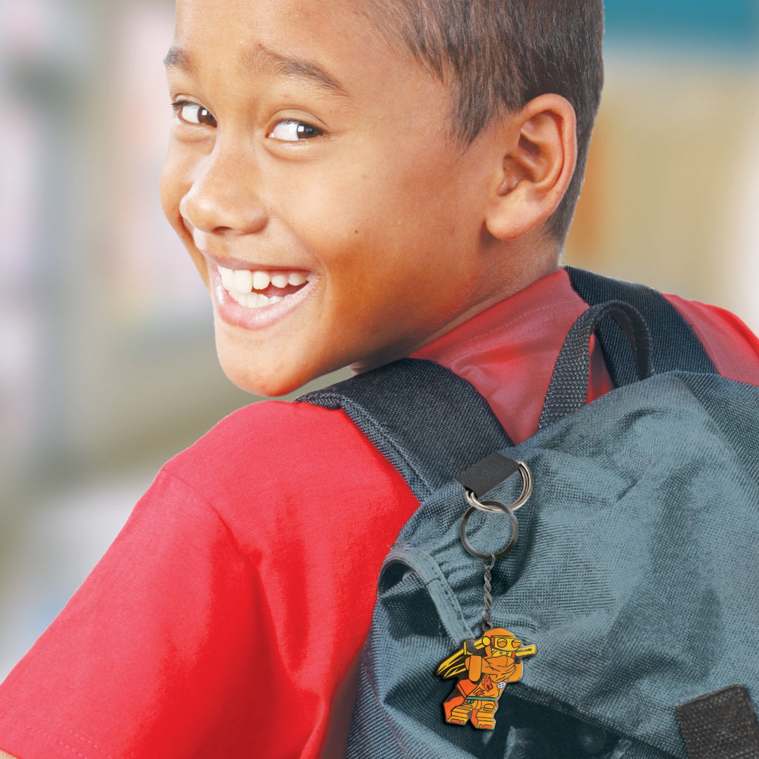 Chłopiec z uśmiechem noszący brelok LEGO Ninjago Arin przypięty do czarnego plecaka