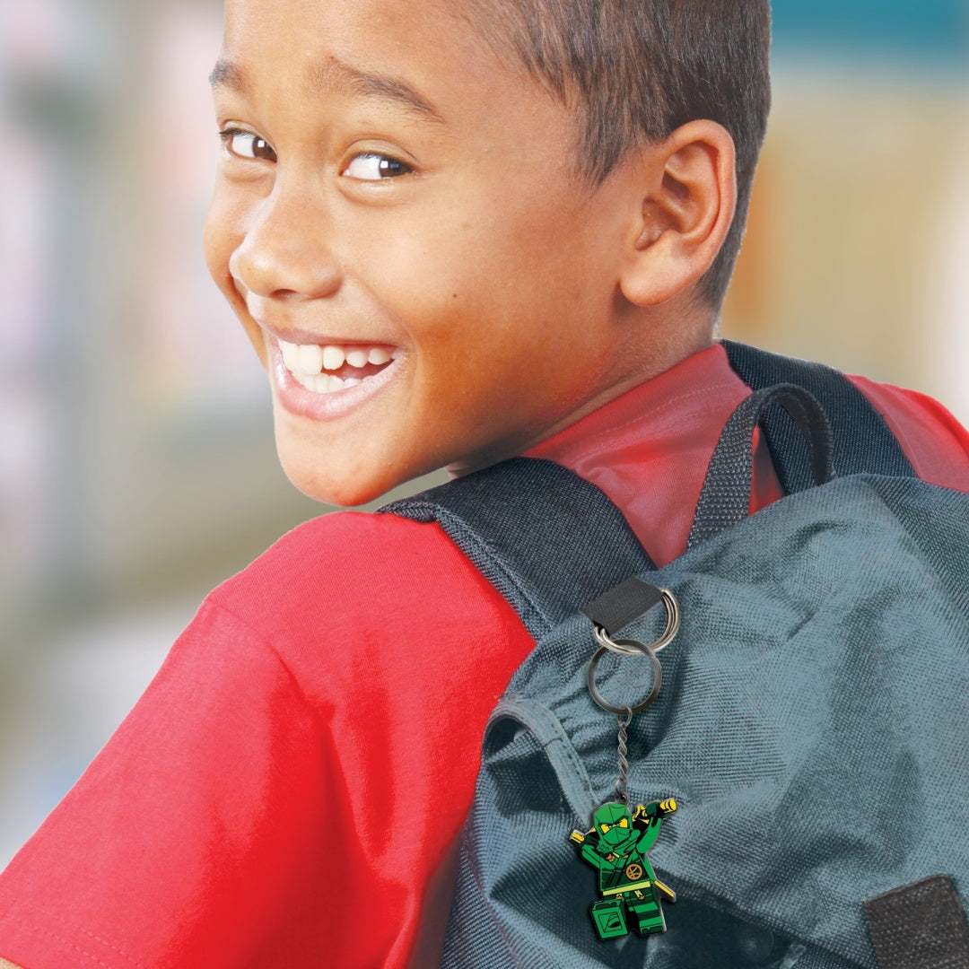 Chłopiec z czerwonym plecakiem z brelok LEGO Ninjago Lloyd zawieszonym na pasku plecaka