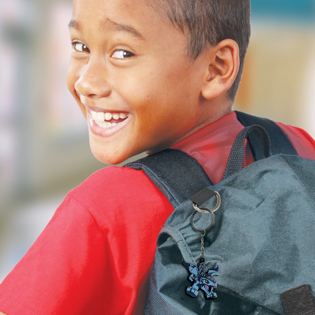 Chłopiec z uśmiechem noszący plecak z brelok LEGO Ninjago Riyu przypiętym do paska