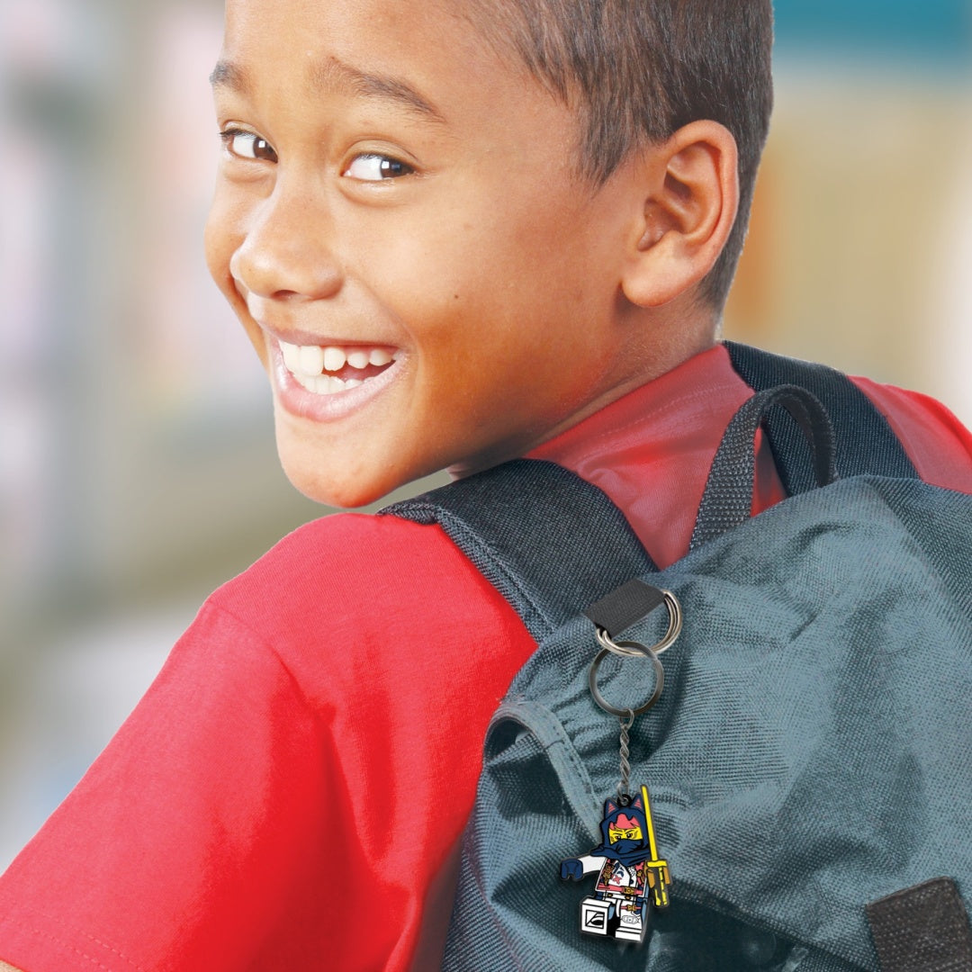 Chłopiec z uśmiechem noszący plecak z brelok LEGO Ninjago Sora zawieszonym na pasku