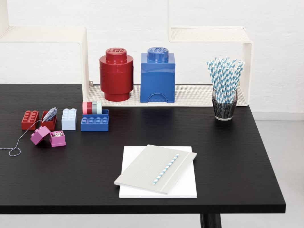 Minipudełko LEGO czerwone i niebieskie na czarnym biurku z akcesoriami do biura