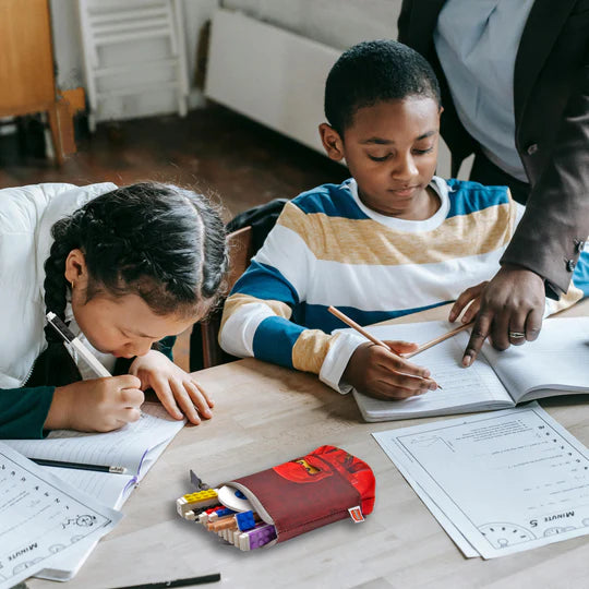 Piórnik LEGO Ninjago Kai na biurku z kolorowymi przyborami szkolnymi obok uczniów podczas nauki