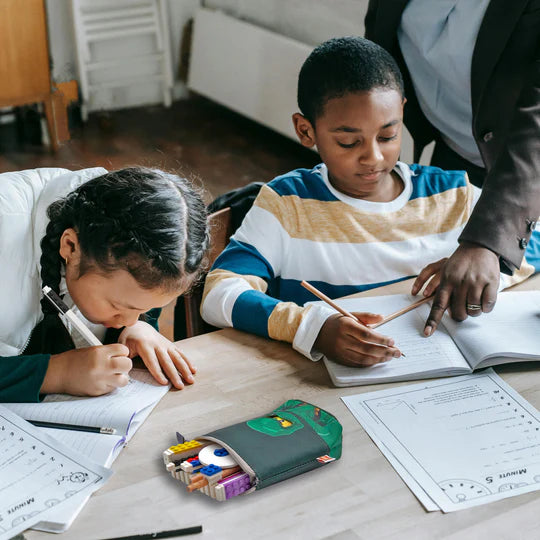 Piórnik LEGO Ninjago Lloyd na biurku obok dzieci odrabiających lekcje