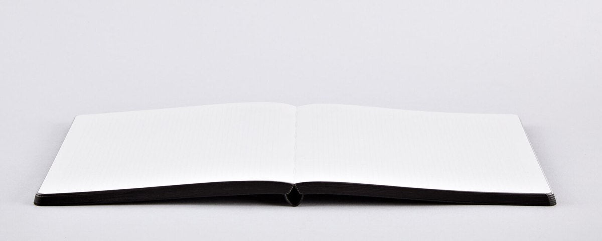 Otwarty notatnik Colour Clash L z pustymi białymi stronami na białym tle