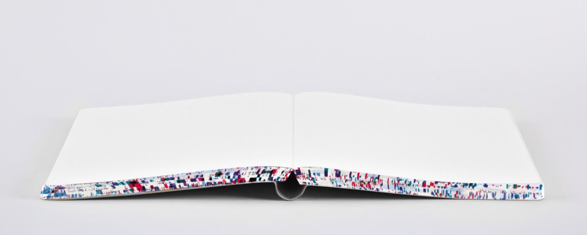 Otwarty notatnik Matrix L z kolorowymi brzegami kartek na białym tle