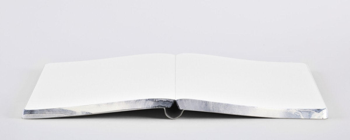 Otwarty notatnik Zen w twardej oprawie z pustymi białymi kartkami na szarym tle