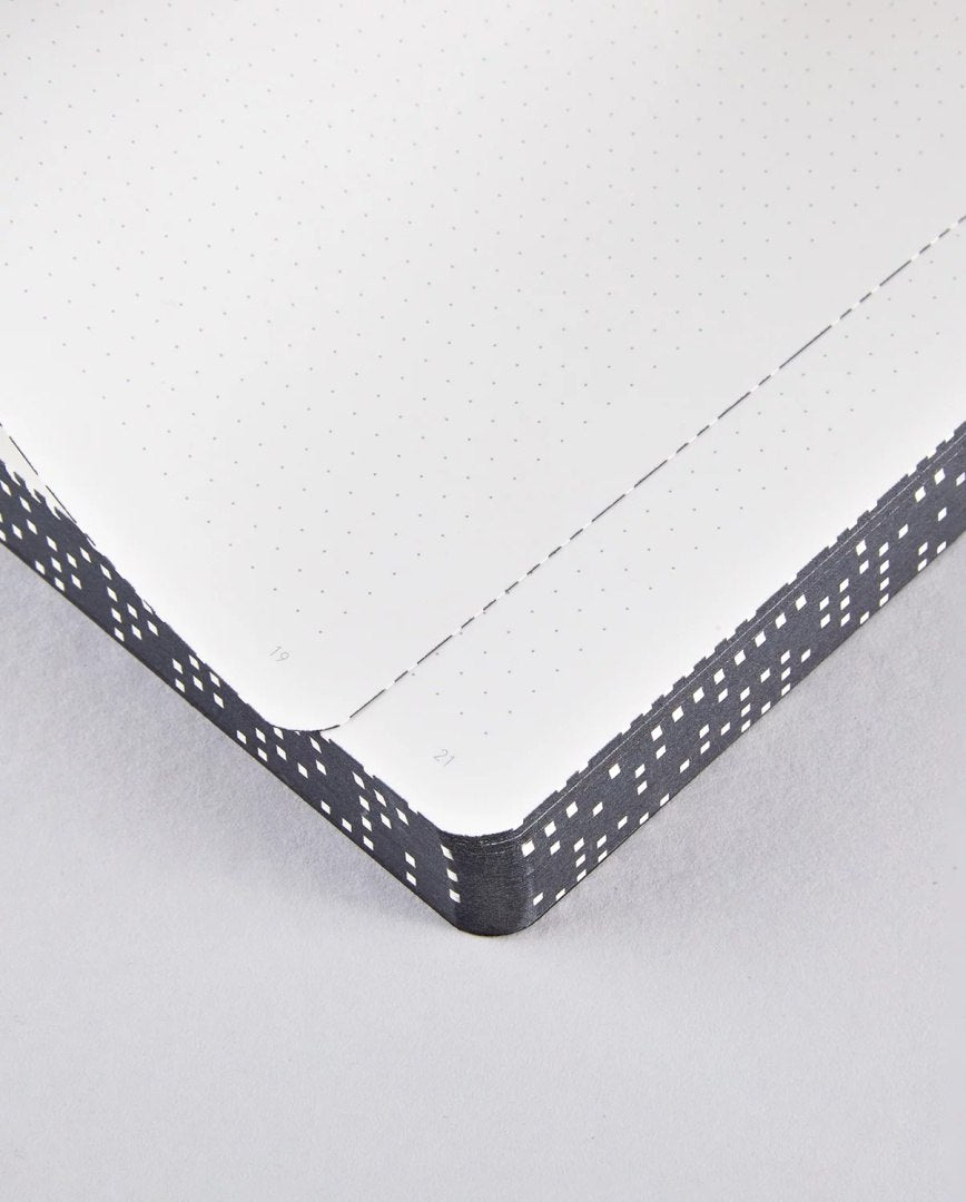 Notatnik graficzny L z punktowanymi stronami i czarną obwolutą z białymi wzorami