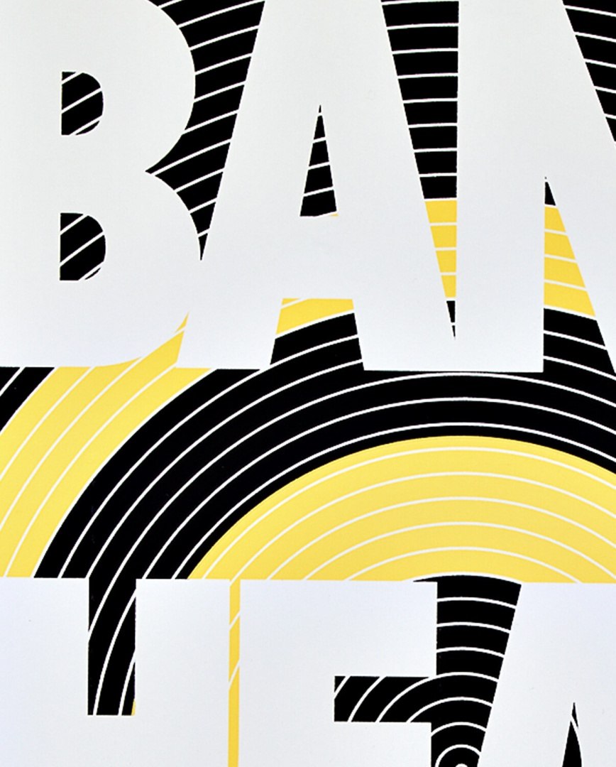 Okładka notatnika Bang Head Here z dużymi białymi literami na tle w żółto-czarne wzory