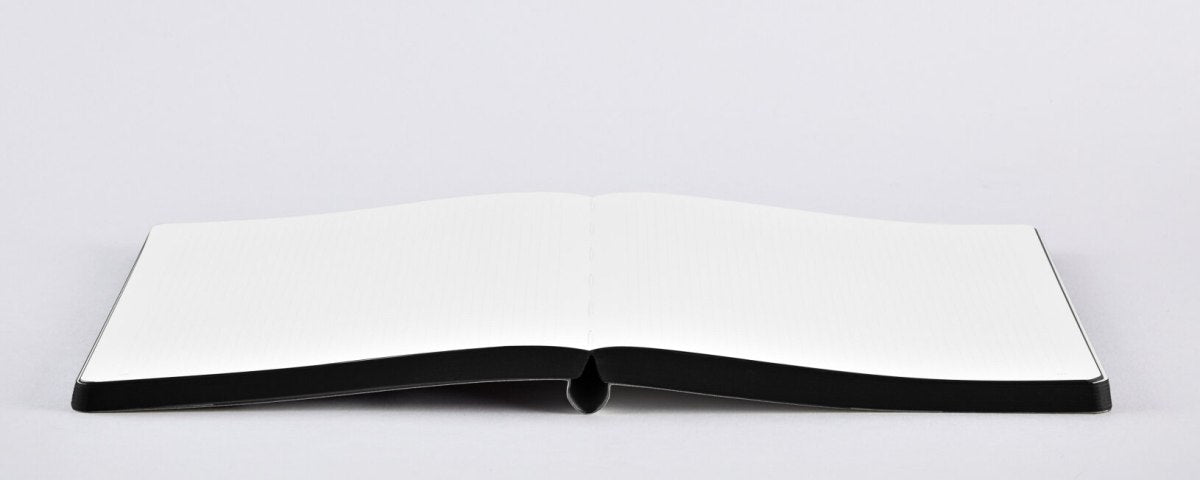 Otwarty notatnik kreatywny z pustymi białymi stronami na szarym tle