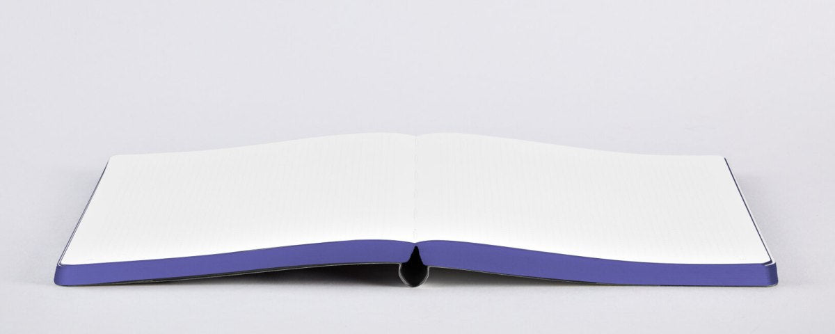 notatnik graficzny na pomysły otwarty na płycej powierzchni z białymi kartkami